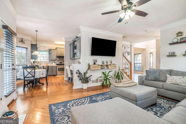 living room featuring crown molding, light parquet floors, a textured ceiling, and ceiling fan