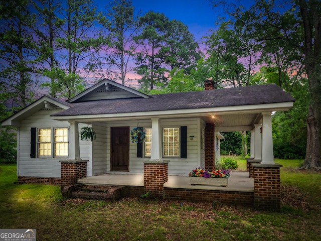 view of front of home with covered porch and a chimney