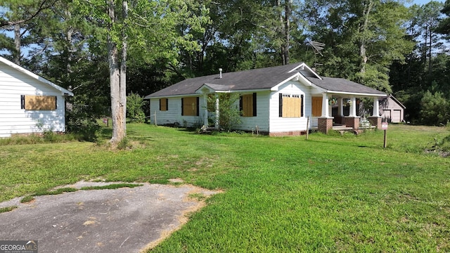 view of front of home with a garage, covered porch, and a front lawn