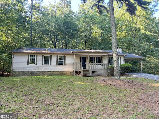 ranch-style home featuring covered porch, a front lawn, and a carport