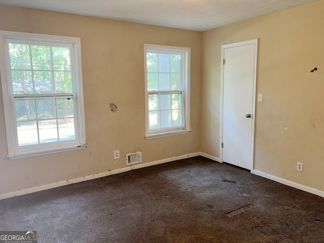 empty room featuring dark carpet