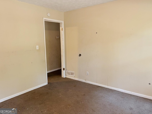 empty room with carpet floors and a textured ceiling