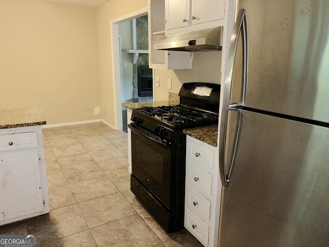 kitchen featuring exhaust hood, dark stone countertops, stainless steel fridge, white cabinetry, and black range with gas cooktop