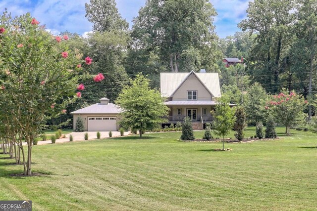 view of front of home featuring a garage, covered porch, and a front lawn