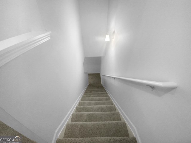 staircase with lofted ceiling and carpet flooring