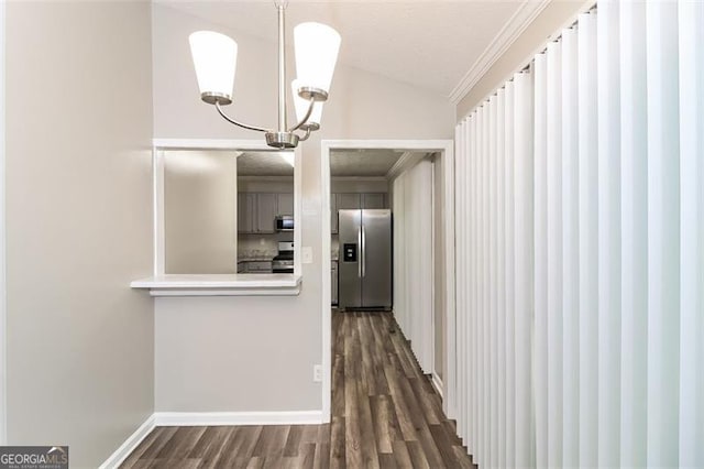 corridor featuring ornamental molding, lofted ceiling, dark hardwood / wood-style floors, and an inviting chandelier