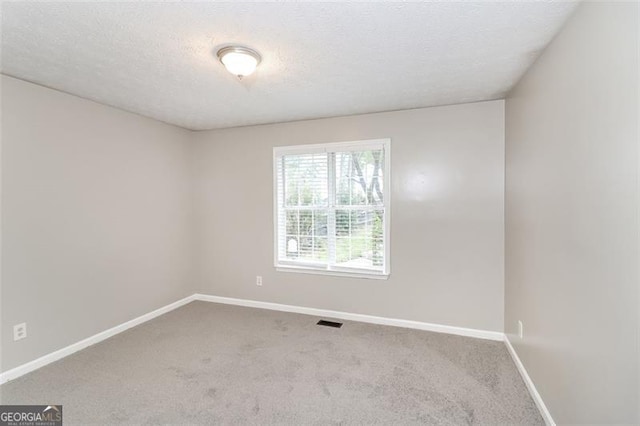 carpeted spare room with a textured ceiling