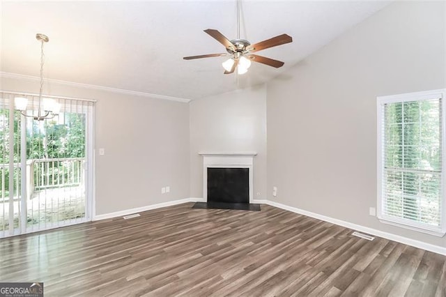 unfurnished living room with ornamental molding, lofted ceiling, dark wood-type flooring, and ceiling fan with notable chandelier