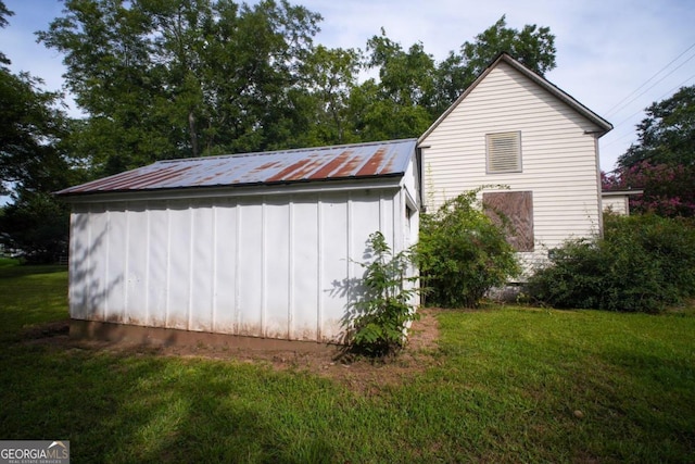 view of property exterior featuring a lawn and an outbuilding