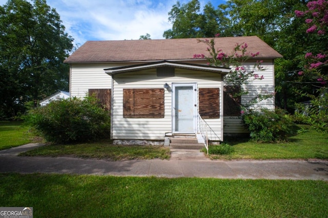 bungalow featuring a front lawn