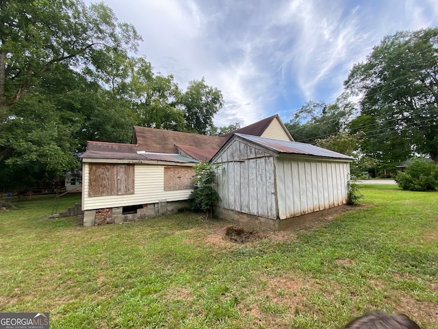 view of side of home with a shed and a yard