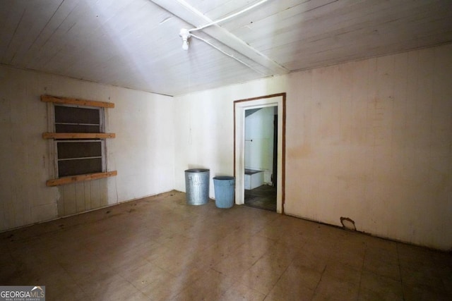 unfurnished bedroom with ensuite bathroom, tile patterned floors, and wooden ceiling