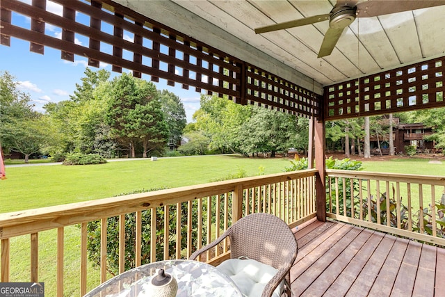 wooden deck with ceiling fan and a yard