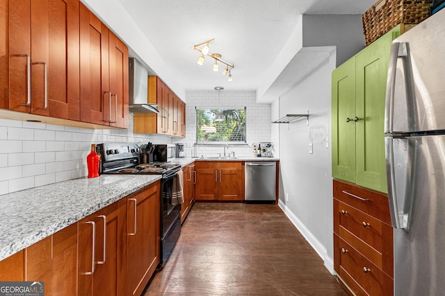 kitchen featuring dark hardwood / wood-style floors, decorative backsplash, light stone counters, stainless steel appliances, and wall chimney range hood