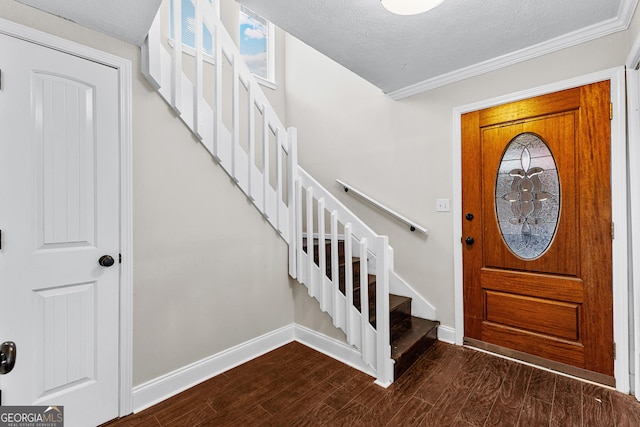 entryway featuring ornamental molding, dark hardwood / wood-style floors, and a textured ceiling