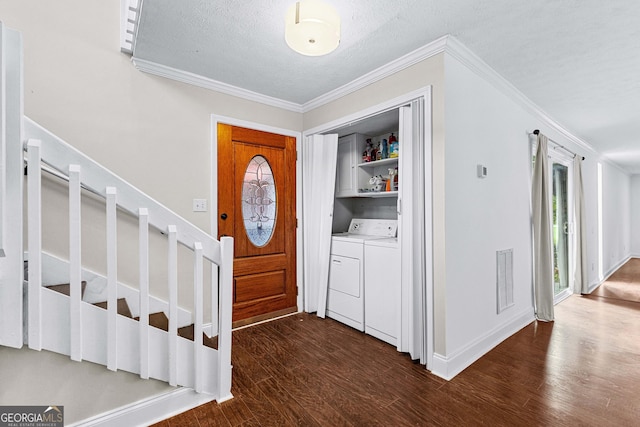 foyer entrance with ornamental molding, dark wood-type flooring, a textured ceiling, and independent washer and dryer