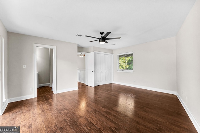 unfurnished bedroom with ceiling fan, dark hardwood / wood-style flooring, and a closet