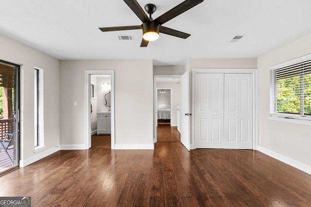 unfurnished bedroom featuring dark wood-type flooring, connected bathroom, a closet, ceiling fan, and access to exterior