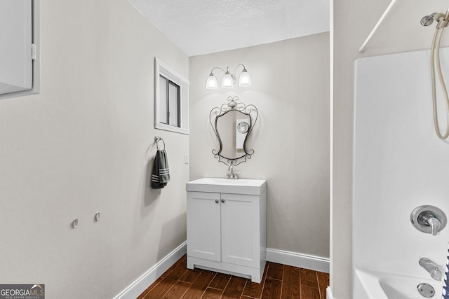 bathroom featuring vanity, a textured ceiling, and  shower combination