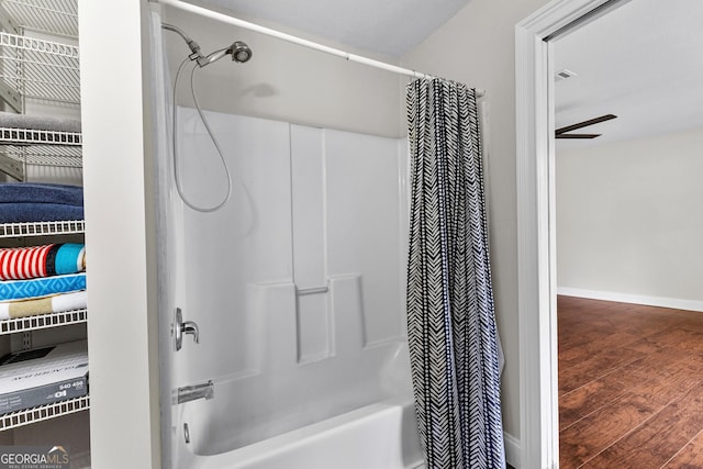 bathroom with hardwood / wood-style floors and shower / bath combo