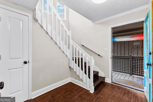 staircase with hardwood / wood-style floors, crown molding, and a textured ceiling