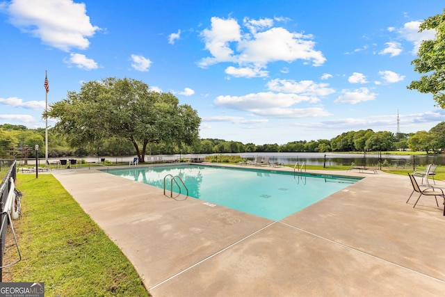 view of swimming pool featuring a patio and a water view