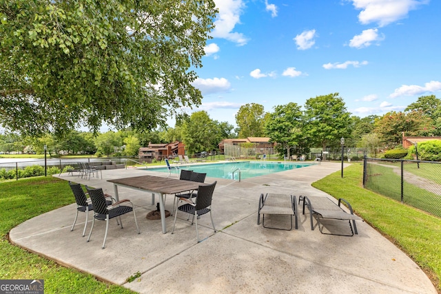 view of swimming pool featuring a yard and a patio