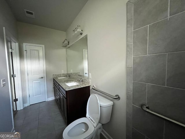 bathroom featuring double vanity, tile patterned floors, and toilet