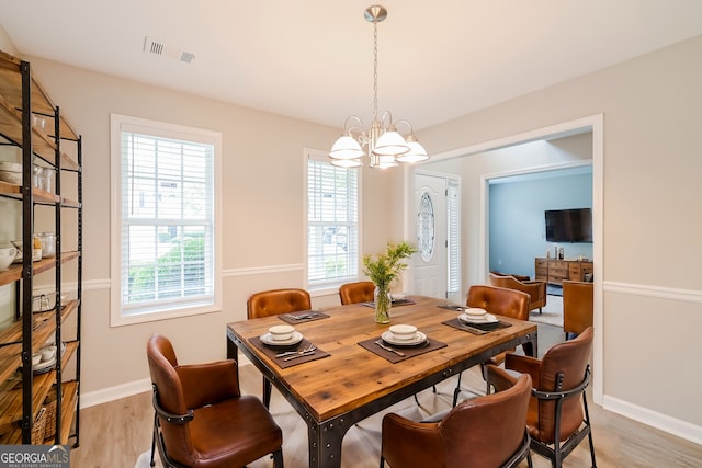 dining space with a chandelier and light hardwood / wood-style floors