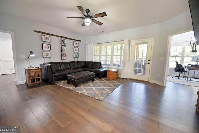 living room featuring dark wood-type flooring and ceiling fan