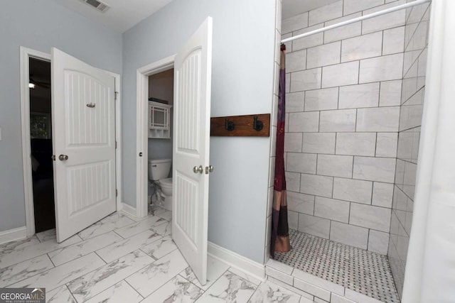 bathroom featuring toilet, tile patterned floors, and a shower with shower curtain