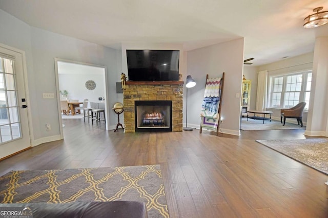 unfurnished living room with a stone fireplace and wood-type flooring