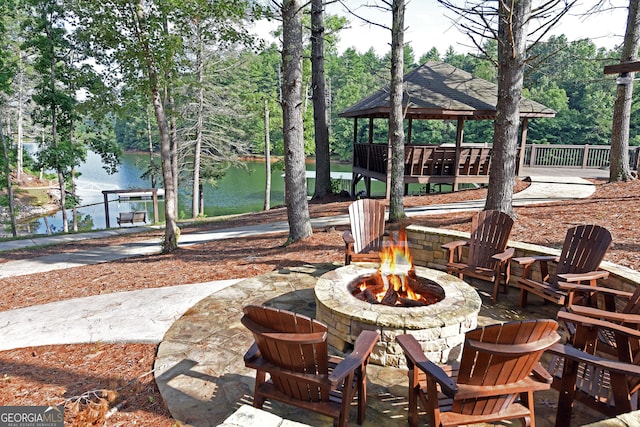 view of patio / terrace with a water view, a gazebo, and a fire pit