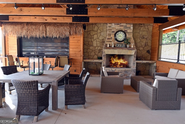 living room featuring concrete floors and an outdoor stone fireplace