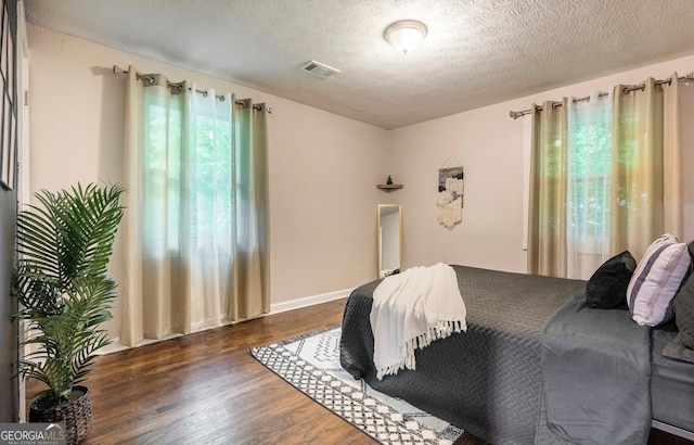 bedroom with a textured ceiling and hardwood / wood-style floors