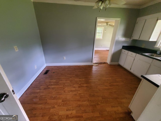 1217 Whispering Pines Rd, Albany, GA 31707 - kitchen with white cabinetry, sink, dark hardwood / wood-style flooring, and ornamental molding