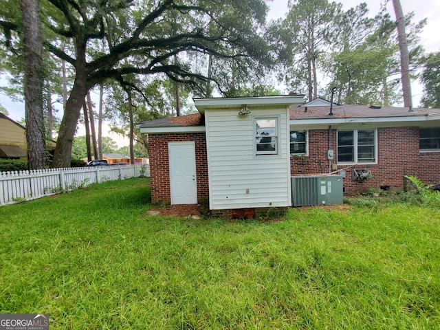 1217 Whispering Pines Rd, Albany, GA 31707 - rear view of house featuring a yard and central AC unit