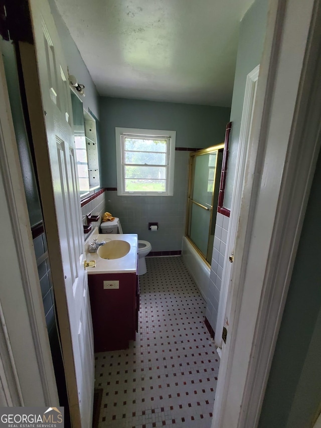 1217 Whispering Pines Rd, Albany, GA 31707 - full bathroom with vanity, combined bath / shower with glass door, tile walls, and toilet