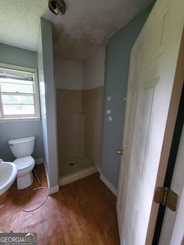 1217 Whispering Pines Rd, Albany, GA 31707 - bathroom featuring hardwood / wood-style floors, a textured ceiling, toilet, and walk in shower