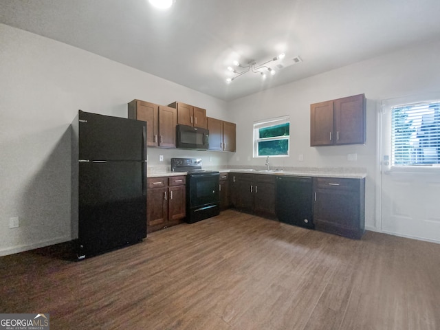 kitchen featuring sink, wood-type flooring, black appliances, and plenty of natural light