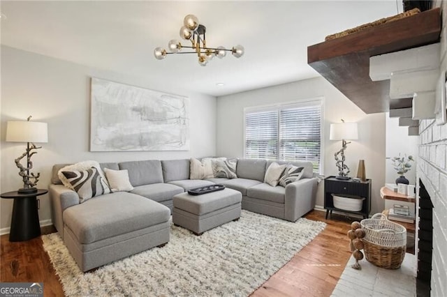 living room with a fireplace, a chandelier, and hardwood / wood-style flooring