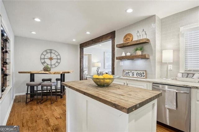 kitchen featuring dishwasher, wood counters, white cabinetry, and light hardwood / wood-style flooring