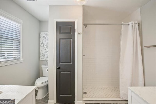 bathroom featuring tile patterned flooring, plenty of natural light, walk in shower, and toilet