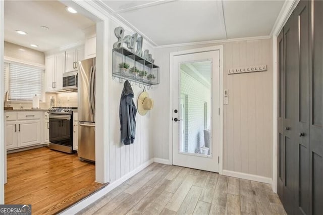 interior space featuring light wood-type flooring and crown molding