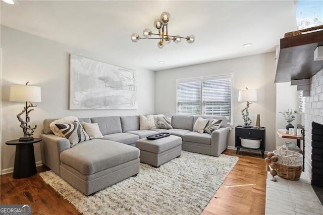 living room with hardwood / wood-style floors, an inviting chandelier, and a fireplace