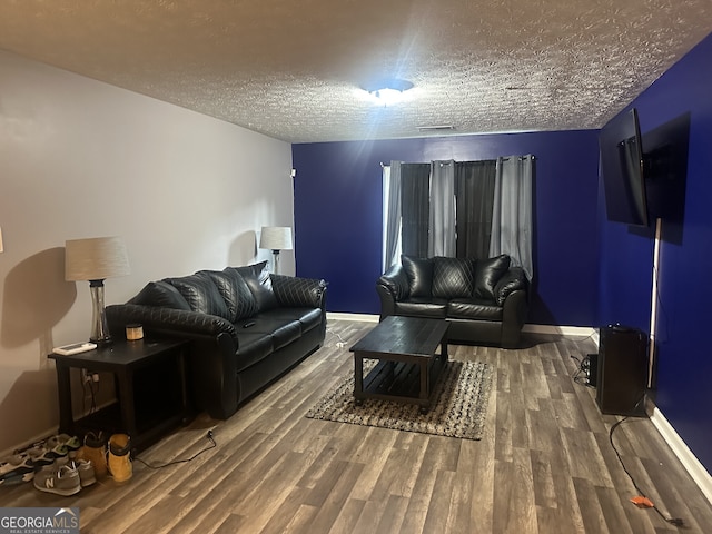 living room with a textured ceiling and wood-type flooring