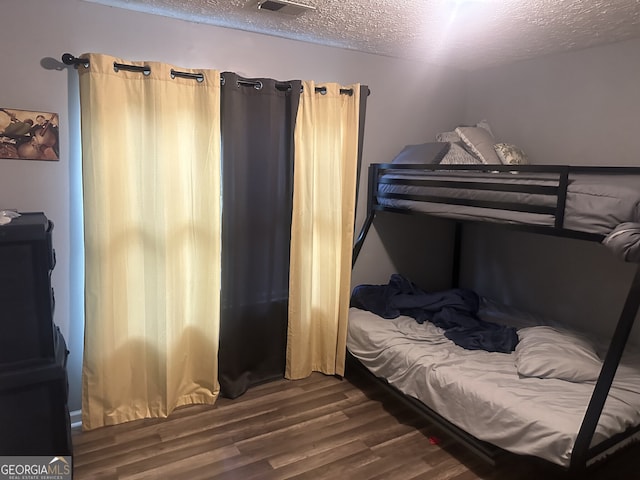 bedroom featuring dark hardwood / wood-style flooring and a textured ceiling