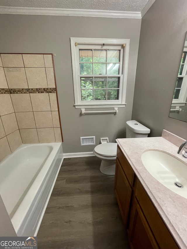 bathroom with a textured ceiling, toilet, vanity, hardwood / wood-style flooring, and ornamental molding