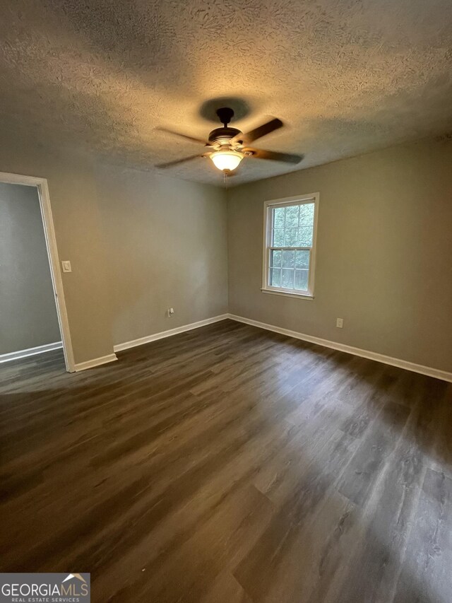 spare room featuring a textured ceiling, ceiling fan, and dark hardwood / wood-style floors