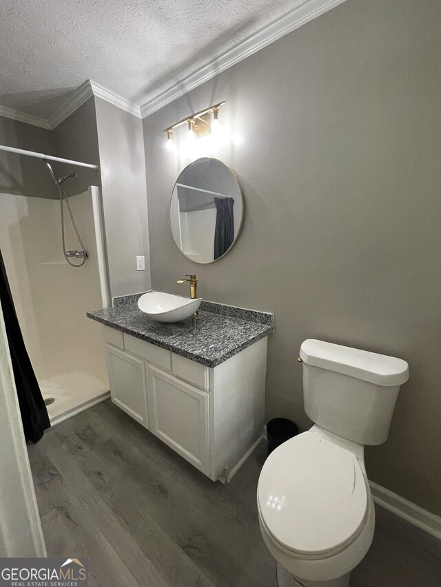 bathroom featuring wood-type flooring, a shower, ornamental molding, toilet, and a textured ceiling